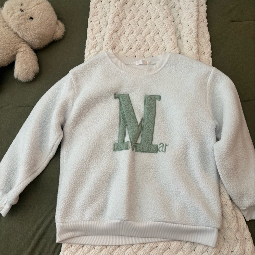 Light Blue Fuzzy Pullover with Green 'M' Graphic